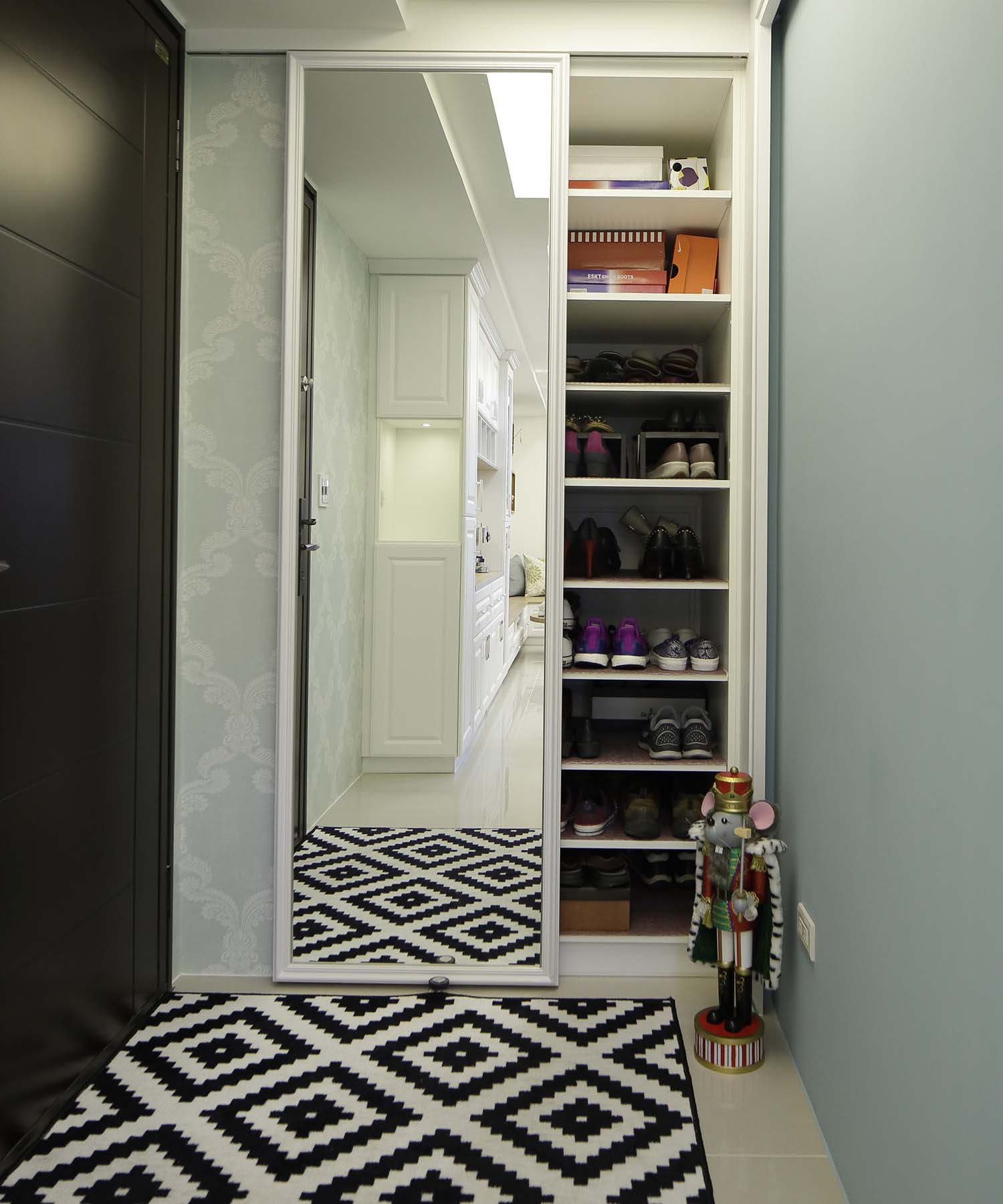 置頂的收納櫃再加上拉門,是小空間玄關放大收納量的好方法;